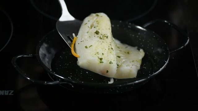 cooking and flipping a fresh cod loin in the pan