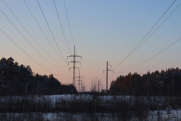 Power lines in the forest. Winter evening landscape.