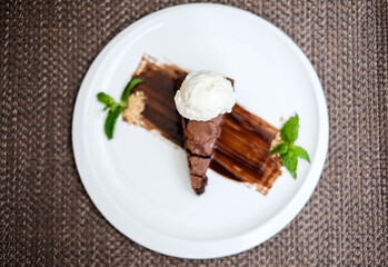 A slice of rich chocolate cake with a scoop of ice cream