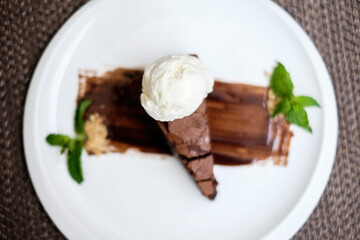 A slice of rich chocolate cake with a scoop of ice cream