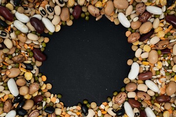 una cornice di legumi e cereali su sfondo nero