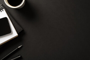 Workplace of modern style company worker concept. Flat lay above overhead view photo of digital cellphone espresso leather planner and pen isolated black backdrop with blank space