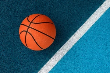 Rolgordijnen Orange basketball on blue court of gymnasium sport floor. Team sport concept © Augustas Cetkauskas