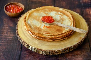 Traditional Russian thin pancakes (crepes) with red caviar.	
