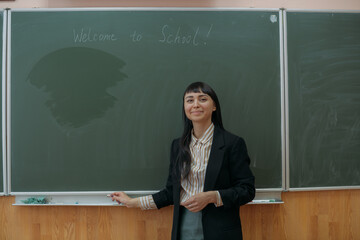 Portrait of a young teacher at the blackboard at school