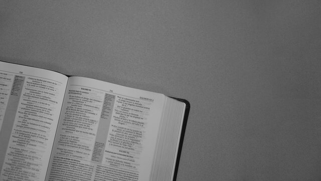 Santa Biblia abierta en el libro de Salmos cap&iacute;tulo 91 en escala de grises, frase de alegr&iacute;a y motivaci&oacute;n