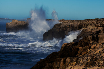 Huge waves hitting the cliff and exploding