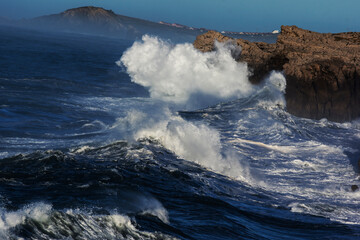 Huge waves hitting the cliff and exploding