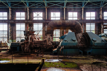 Rusty turbine generator. Abandoned destroyed by war and overgrown by plants and moss machinery of Tkvarcheli Tquarchal power plant, Abkhazia, Georgia