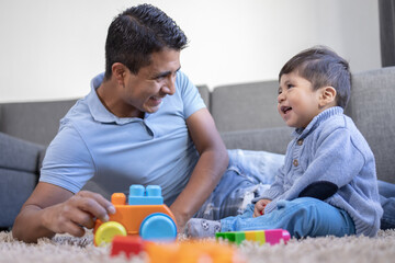 Obraz premium Mexican father and child playing with blocks, father's day