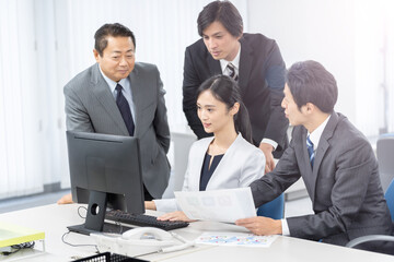 Fototapeta premium オフィスでパソコンに注目する人々