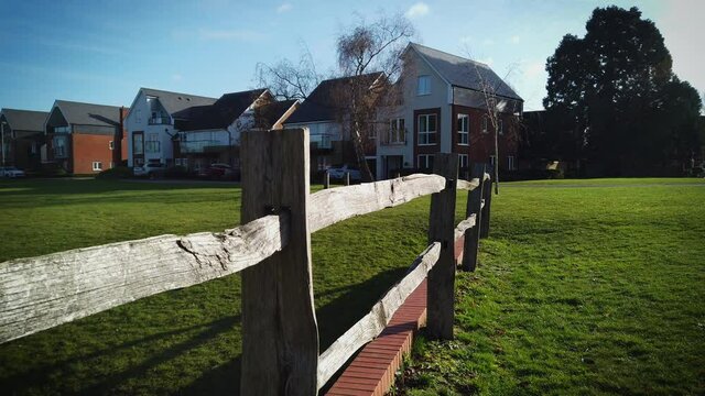 Beautiful green but empty park in UK during the covid 19 pandemic. View next to rough wooden fence above the drainage canal 