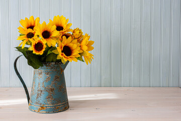 Beautiful silk sunflowers in blue antique watering can.