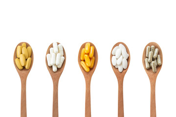 Top view Variety of vitamin and mineral pills in wooden spoon isolated on white background Clipping path.