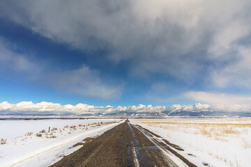 Straight Rural Snowy Road Heading to Mountains in Teton Valley Idaho