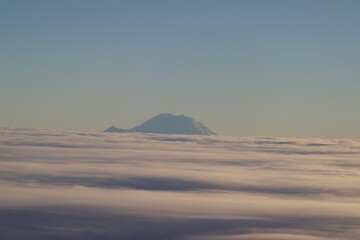 Fototapeta na wymiar Mount Rainier emerging from the clouds, viewed from a plane, Washington, USA