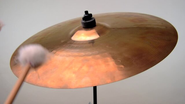 A soft mallet roll is being performed on a cymbal to produce a rising then falling crescendo