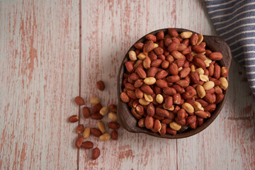 peanuts in a clay pot on a wooden table