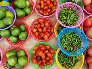 Cherry tomatoes, limes, green and red bell peppers are all organic products grown from the villagers' back gardens Place them in round baskets for distribution to customers in vegetable shops.
