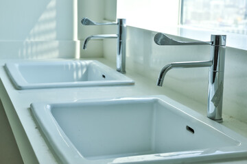 Ceramic sink and modern tap in stylish kitchen interior. Interior home styling classic and modern kitchen water tap.