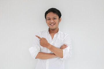 Smile of Young Asian man in white shirt with hand point on empty space