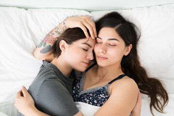 Fototapeta na wymiar Relaxed women in a relationship embracing each other in bed