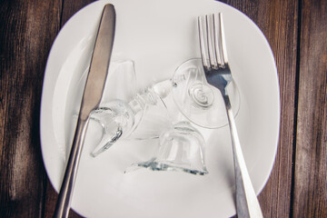 broken glass on a plate table setting cutlery wooden table