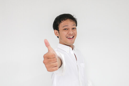 Young Asian man wear grey shirt with happy smiling face and thumbs up or ok sign