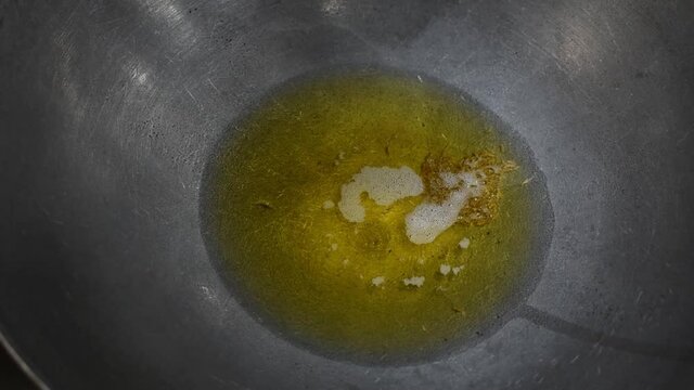 Boiling jeera and hing powder with green chilly and curry leaves in oil