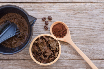 Dry Henna leaf, Herbal Henna hair dye powder and coffee powder in wooden on wood table. Natural product for organic hair colouring concept. Top view. Flat lay.