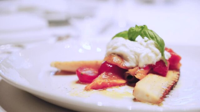 Octopus with stracciatella and vegetables. Octopus dish. Serving dish in a restaurant. Ready dish on the table.