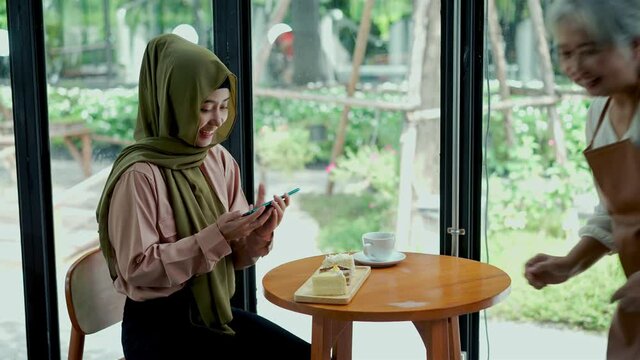 Young muslim woman take a picture cake with smartphone