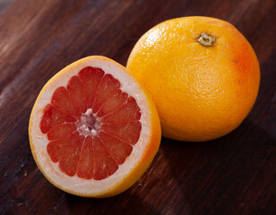 Fresh grapefruit sliced on light wooden background