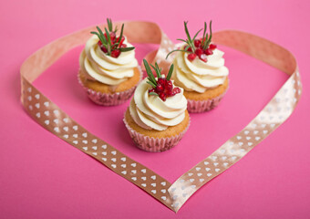 Valentines cupcakes with vanilla icing on a pink background