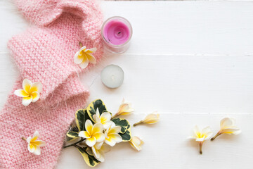white flowers frangipani flora local of asia with pink knitting wool scarf of lifestyle woman relax in winter season decoration on background white wooden
