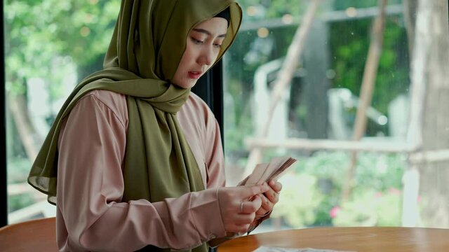 Young muslim woman split money and laid aside for expenses.