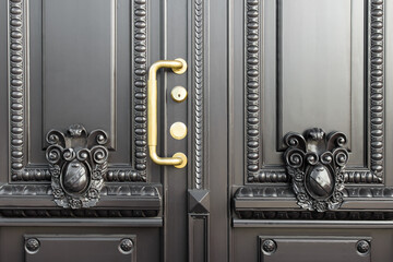 Vintage carved luxury expensive entrance door with detailed decor and golden handle.