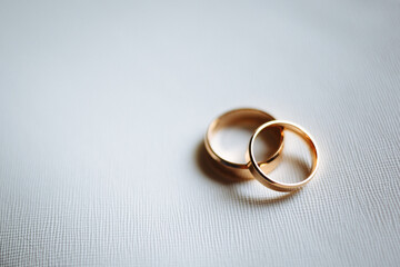 Obraz na płótnie Canvas Two golden wedding rings on white background.