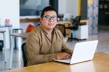 plus size latin man working on laptop in office in Mexico city