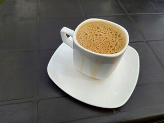 A tea or coffee cup on a table in a restaurant . Close up.