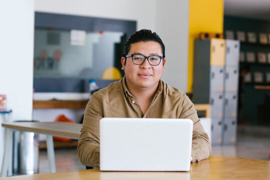 Plus Size Latin Man Working On Laptop In Office In Mexico City