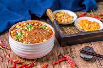 Sichuan gourmet hot and sour noodles placed on wooden table 