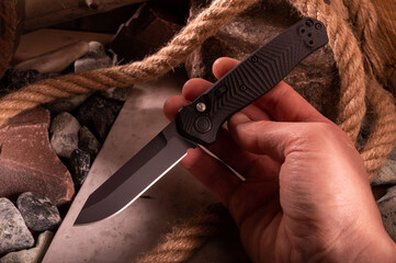 Obraz premium Black pocket knife in hand. Automatic folding knife.