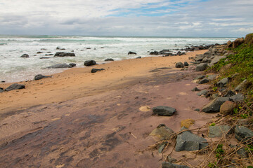 Stretch of Wet Beach and Rocks with Ebbing Tide
