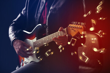 Fototapeta na wymiar Man playing guitar on dark background