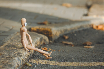 Wooden mannequin wearing medical mask outdoors