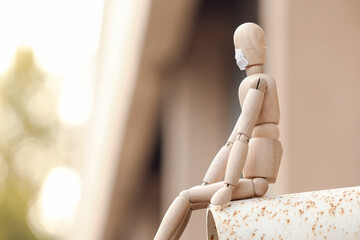 Wooden mannequin wearing medical mask outdoors