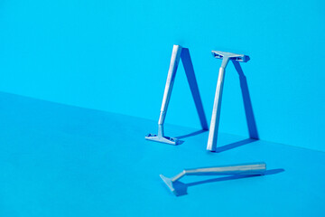 Disposable razors on blue background, studio shot