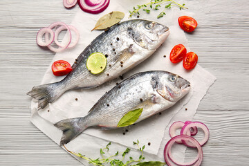 Raw dorado fish with ingredients on wooden background