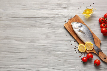 Raw dorado fish with ingredients on wooden background